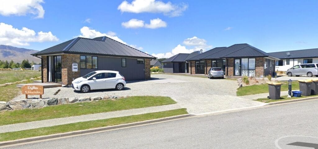 Modern brick holiday homes with driveways and parked cars